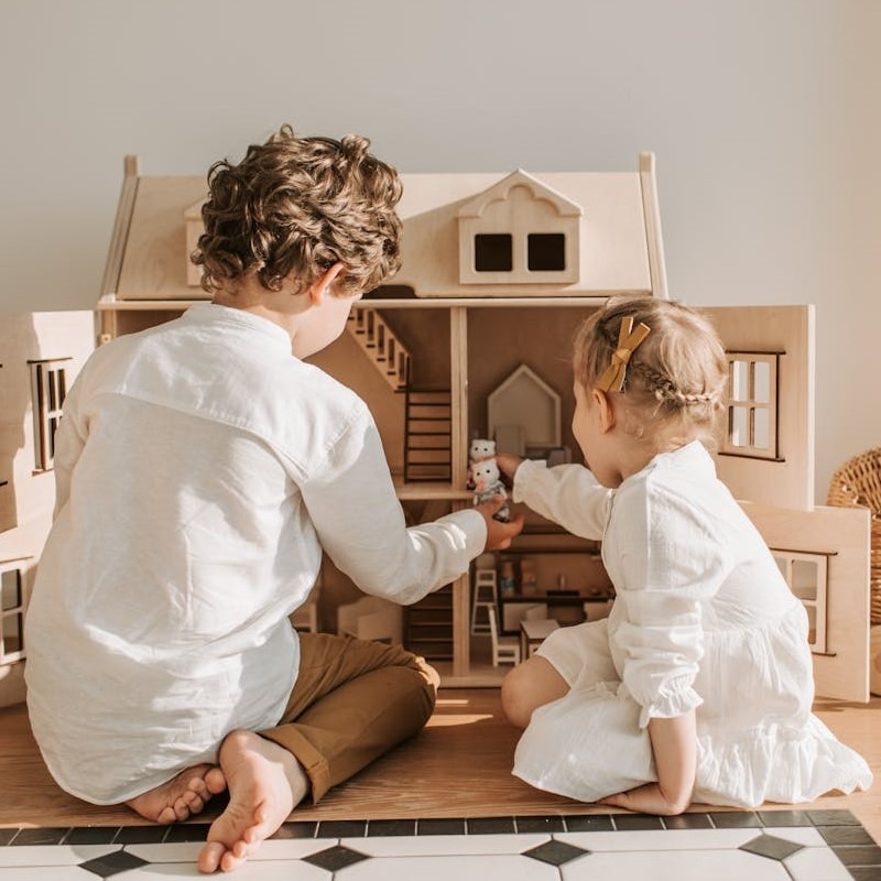 kinder-spielen-vor-grossem-puppenhaus